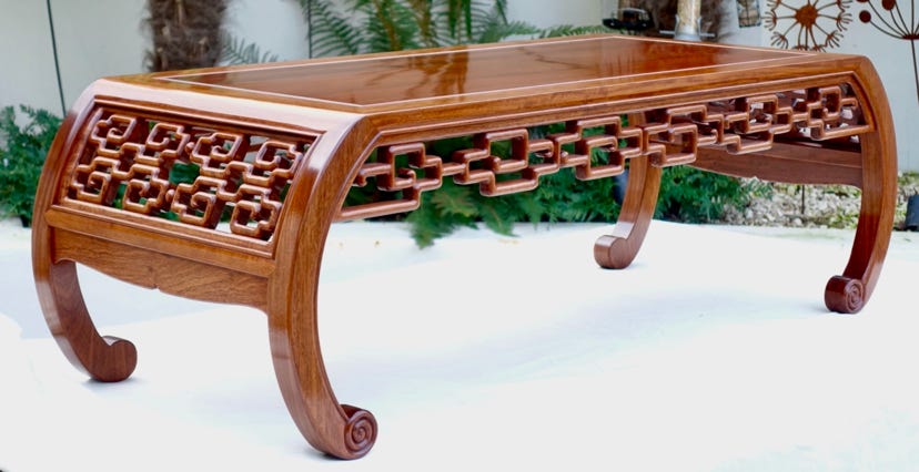 Rosewood coffee table with curved legs and delicate carving to aprons and end panels.